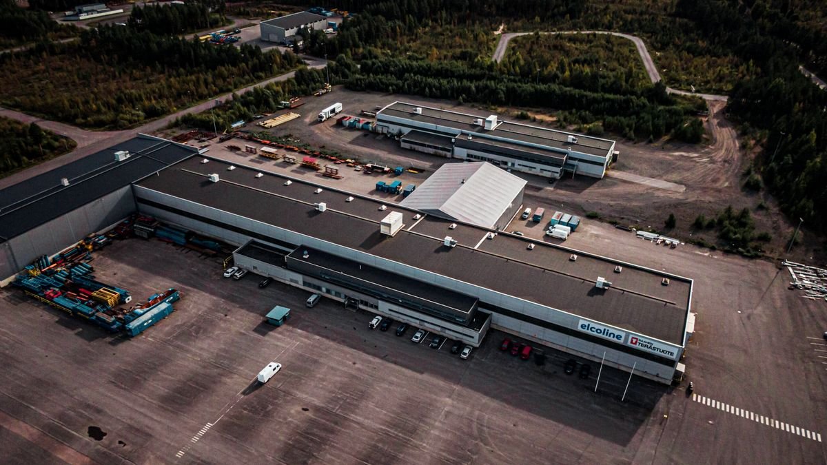 Ilmakuva Terästuotteen tuotantotiloista Raahen Kiiluntiellä: pitkä tuotantohalli, varastokenttä ja toinen halli metsän keskellä.